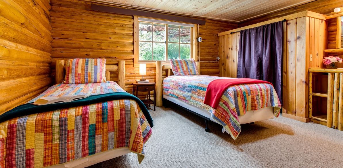 Twin beds in the Dakota cabin with night stand between