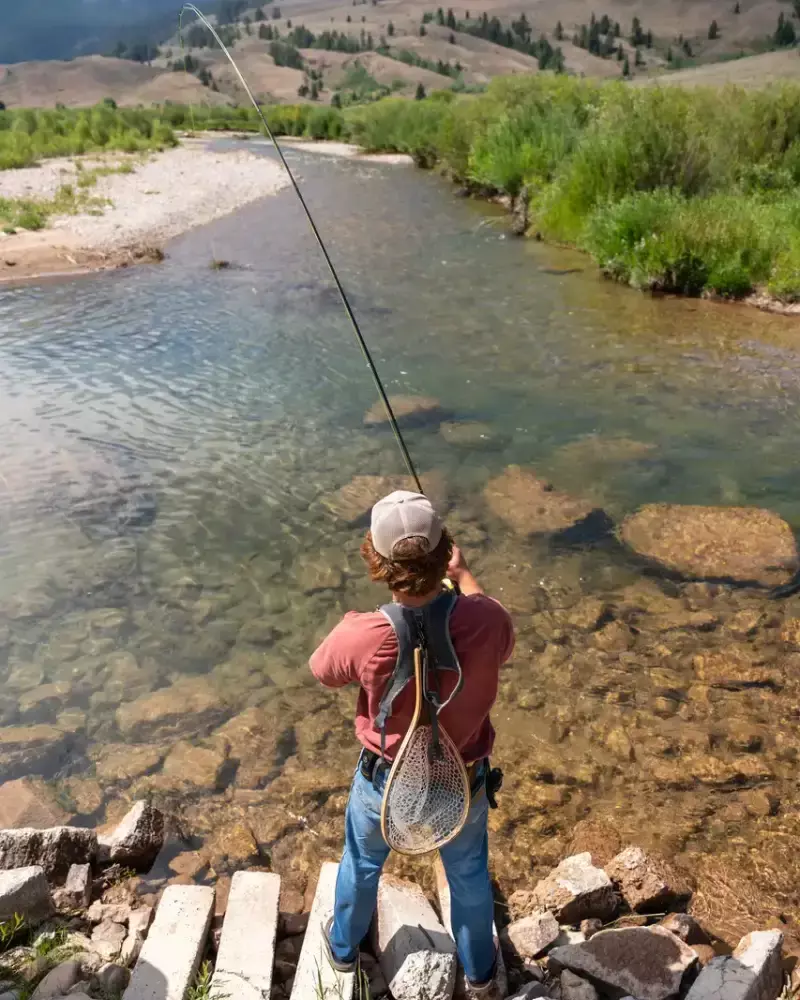 A man fishing on a bridge