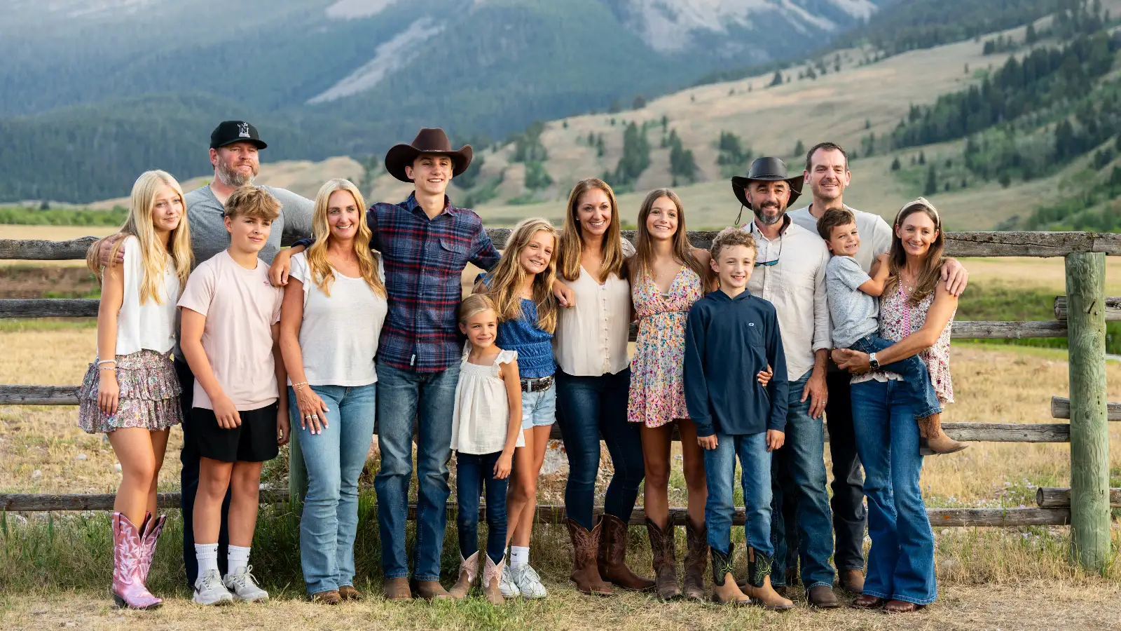 A group of people in western clothing posing for a photo on a hill