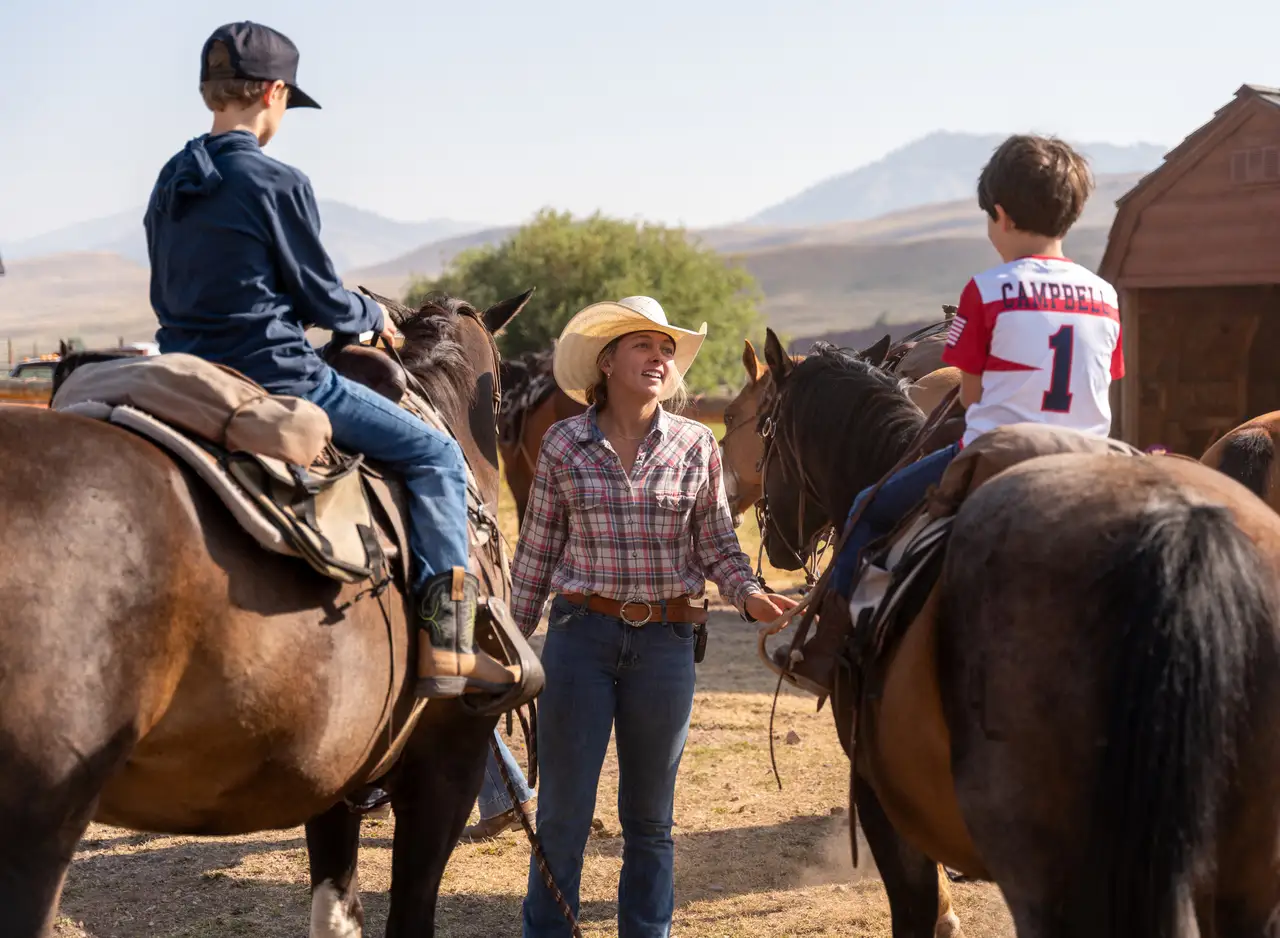 A woman and two boys on horses