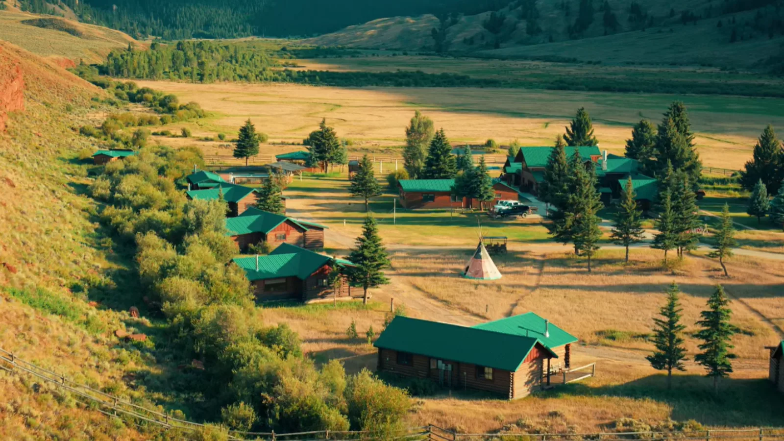 A valley with houses and cabins on a hillside