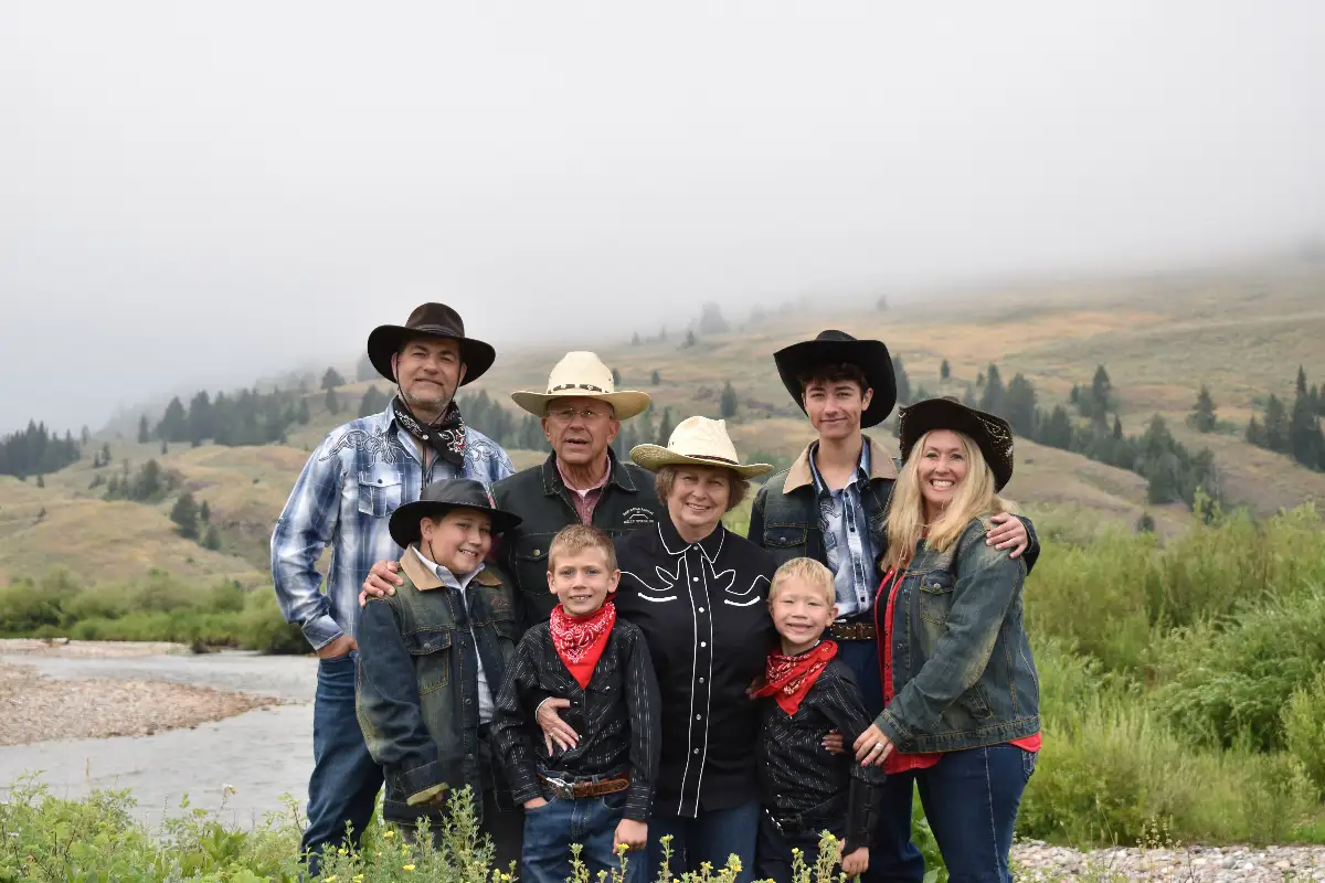 A family posing for a photo in a field with a river in the background