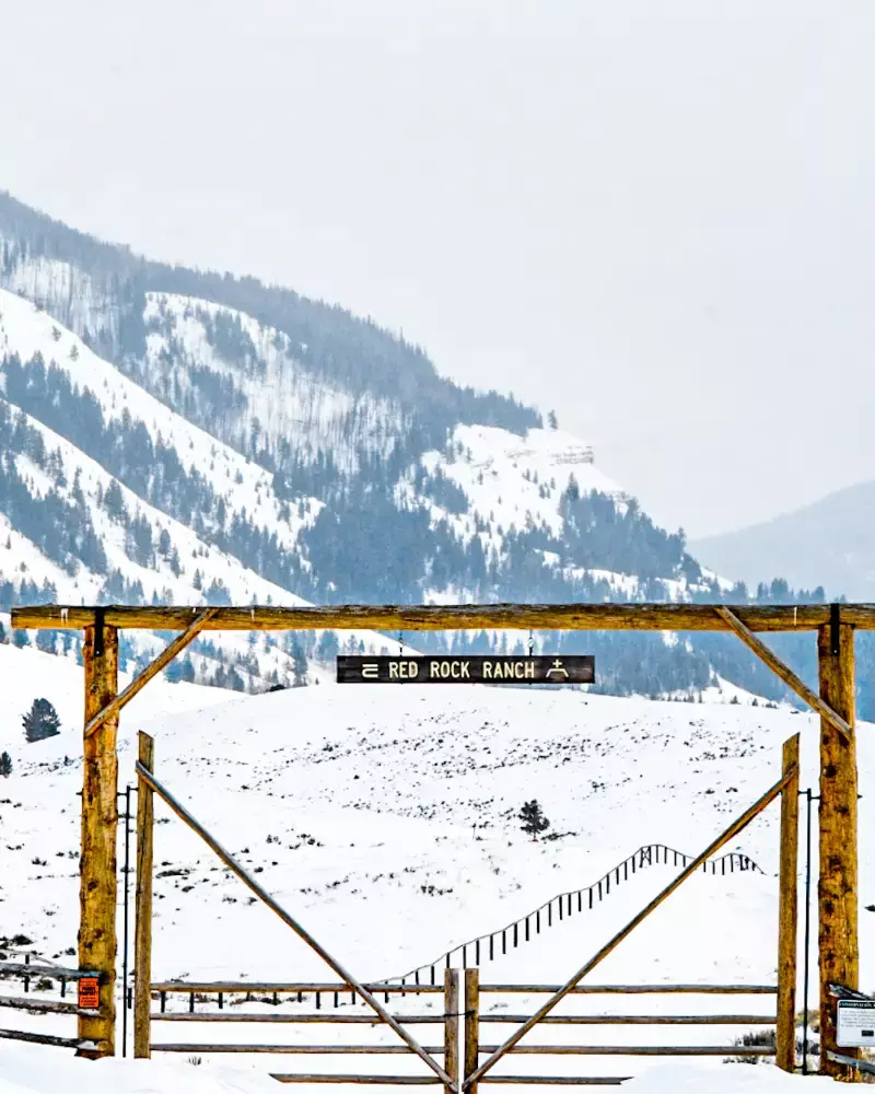 A wooden gate with a sign that reads Red Rock Ranch