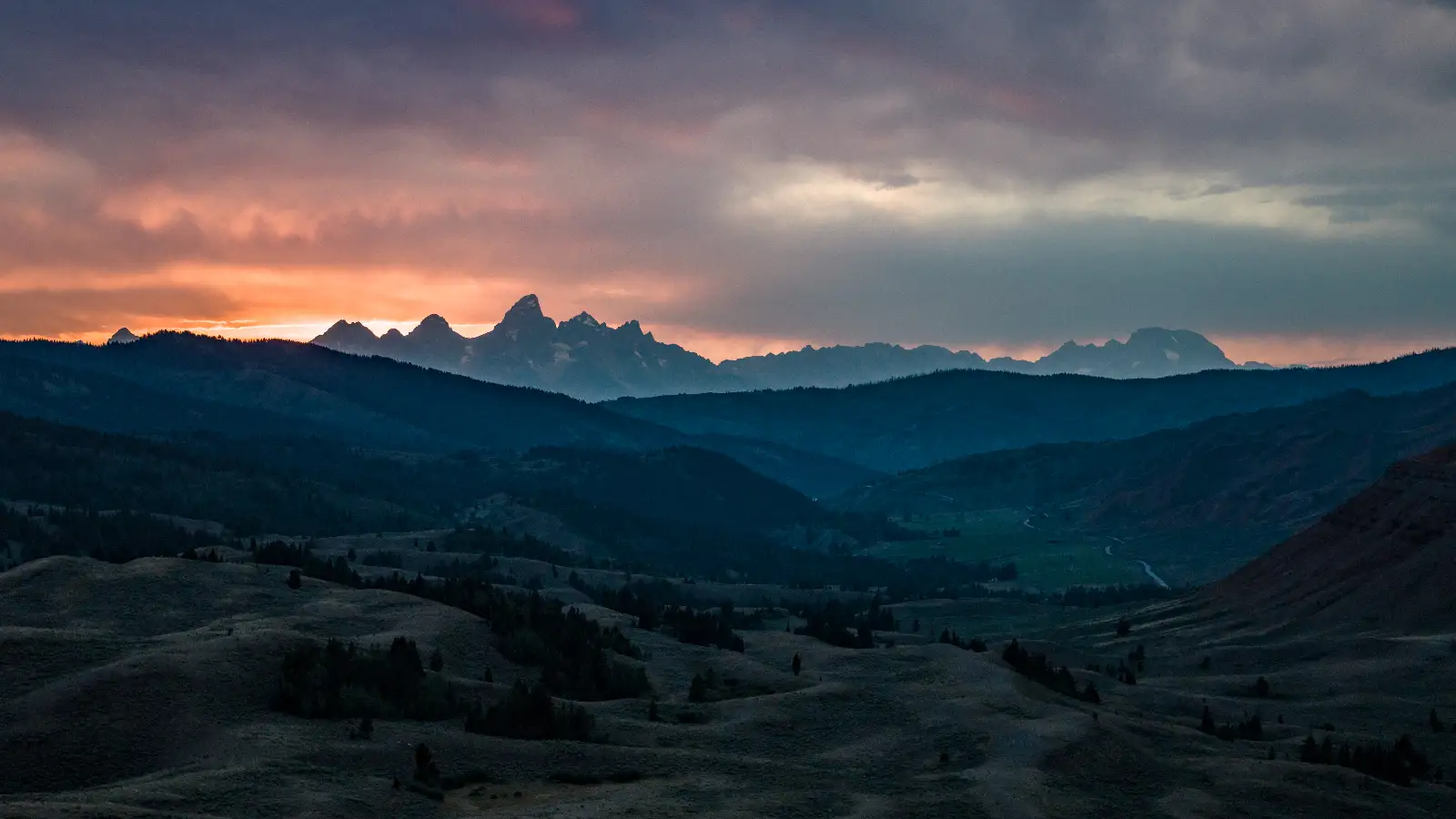 A stunning view of mountains at sunset with clouds in the sky