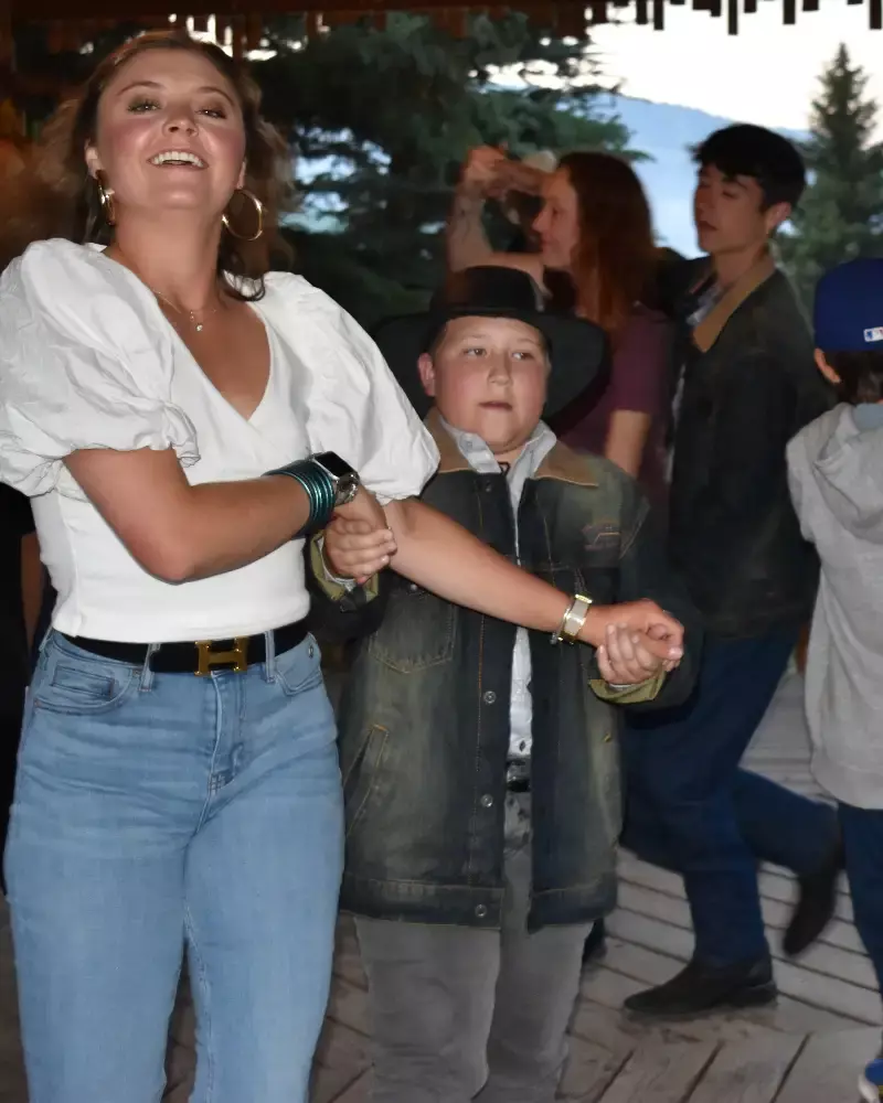 A woman and a boy dancing together with other people around them